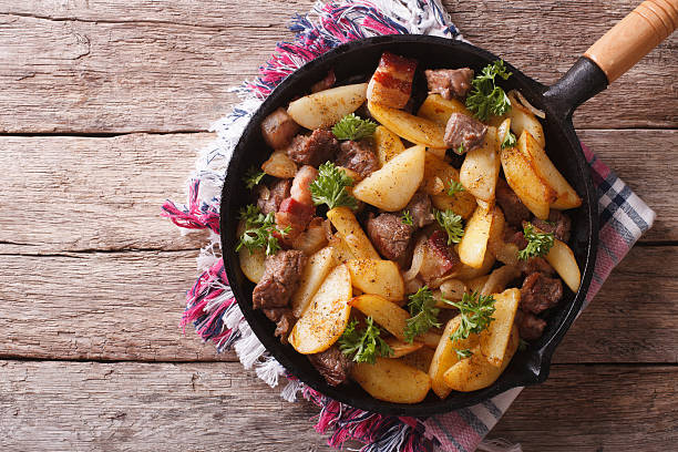 istock rustic fried potatoes with meat in pan. Horizontal top view 508839458