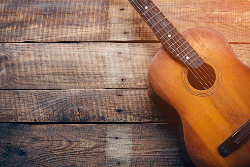 Close-up of guitar lying on vintage wood background
