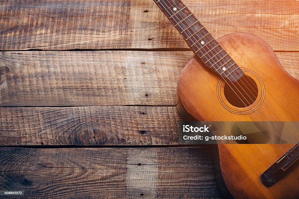 Wooden guitar. Close-up of guitar lying on vintage wood background Guitar Stock Photo