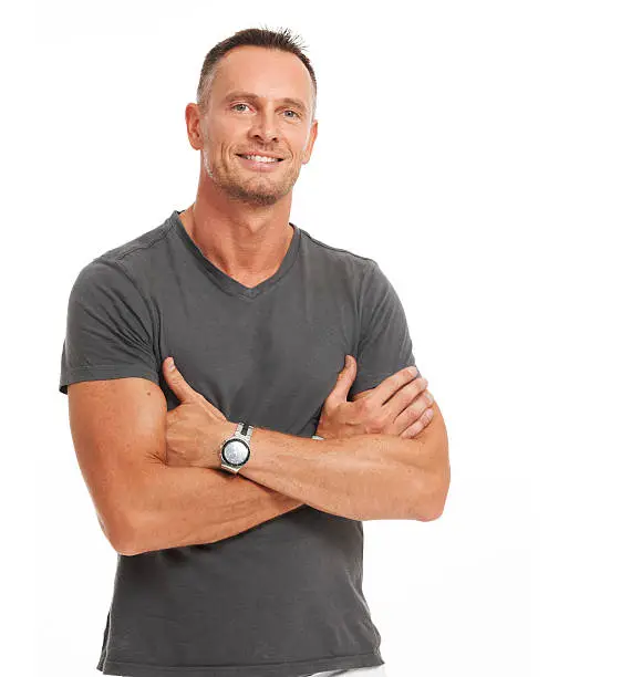 Confident mature man standing with his arms folded isolated on white