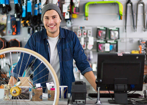 verkäufer in fahrradgeschäft - sales clerk store manual worker retail stock-fotos und bilder