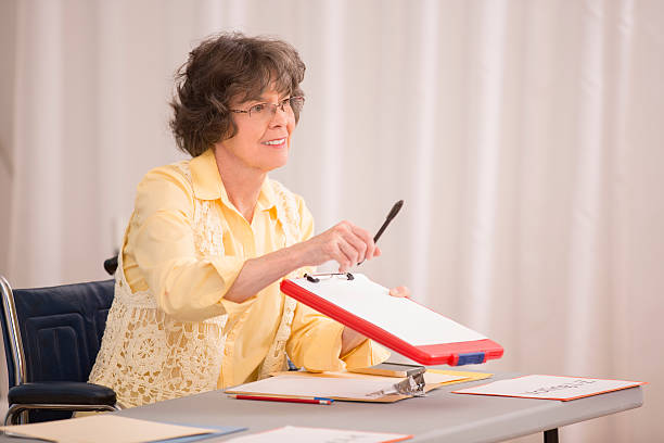 Disabled senior woman at conference or voter registration table.