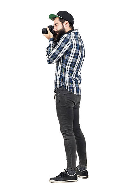 Side view of hipster taking photo with dslr camera