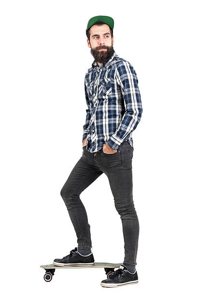 istock Hipster wearing baseball cap standing on longboard looking away 508856784