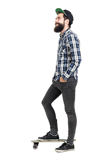 istock Side view of hipster standing on skateboard looking away smiling 508856838