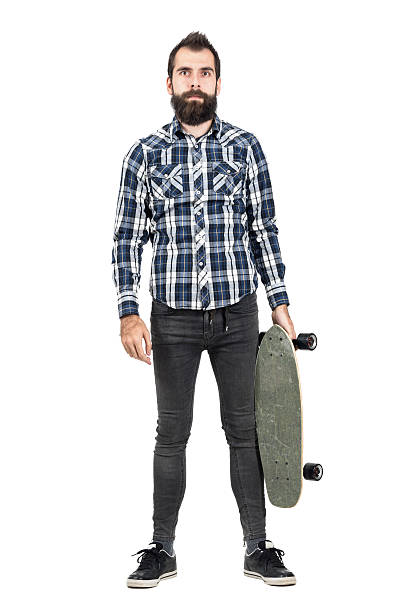 istock Hipster carrying skateboard looking at camera. 508856872