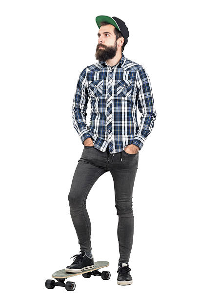 istock Confident bearded hipster wearing baseball cap standing on skate board 508856910