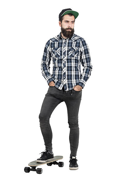 istock Confident bearded hipster with baseball cap standing on skate board 508856946