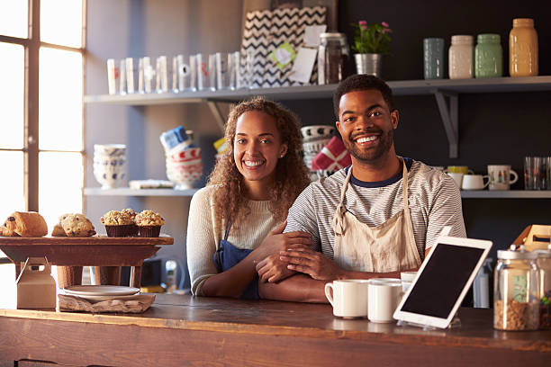 Portrait Of Couple Running Coffee Shop Behind Counter Portrait Of Couple Running Coffee Shop Behind Counter african american business couple stock pictures, royalty-free photos & images