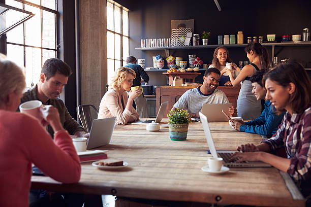 interior de la tienda de café con clientes utilizando dispositivos digitales - atestado fotografías e imágenes de stock