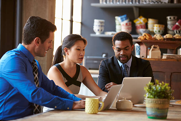 istock Three Businesspeople Working At Laptop In cafe 508858980