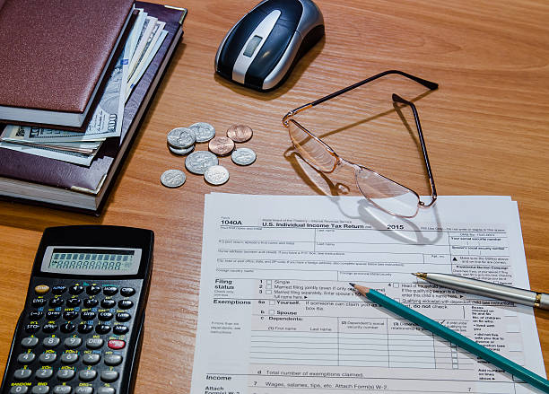 istock 1040 tax form for 2016 with pen, money, notepad, calculator 508859044