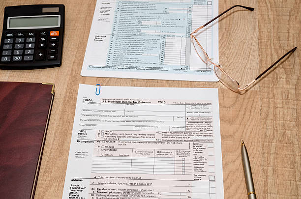 istock 1040 Tax Form with calculator and pen 508859746