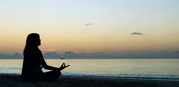 istock young woman doing yoga on sunset beach 508875710