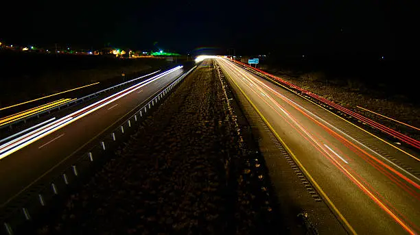 A timed exposure of night time traffic along Interstate 40 as it passes by Tucumcari, New Mexico. I-40 replaced the old hiway 66 or route 66. It is a main artery through the United states especially for the big rigs or semi trucks. 