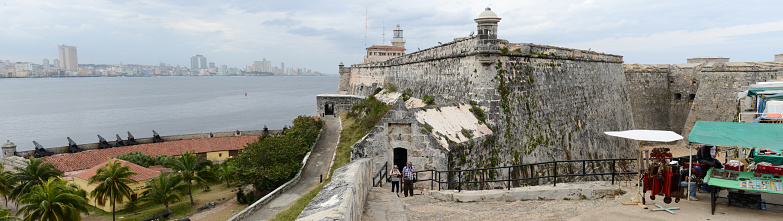 Havana, Cuba - 26 january 2016: People walking and taking picture in front of El Morro fortress with the city of Havana in the background, Cuba