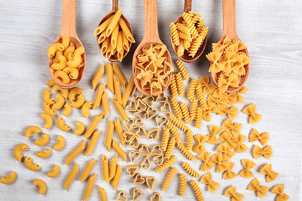 istock Different types of pasta lying in wooden spoons 508881030