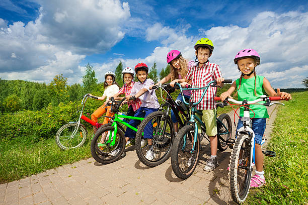 istock Children in row wearing helmets holding bikes 508883013