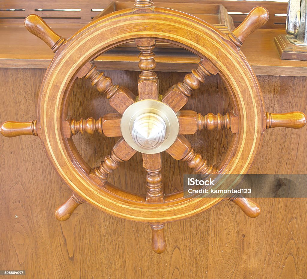 Steering wheel on a wooden boat Wooden and brass rudder on a vintage vessel Aboard Stock Photo