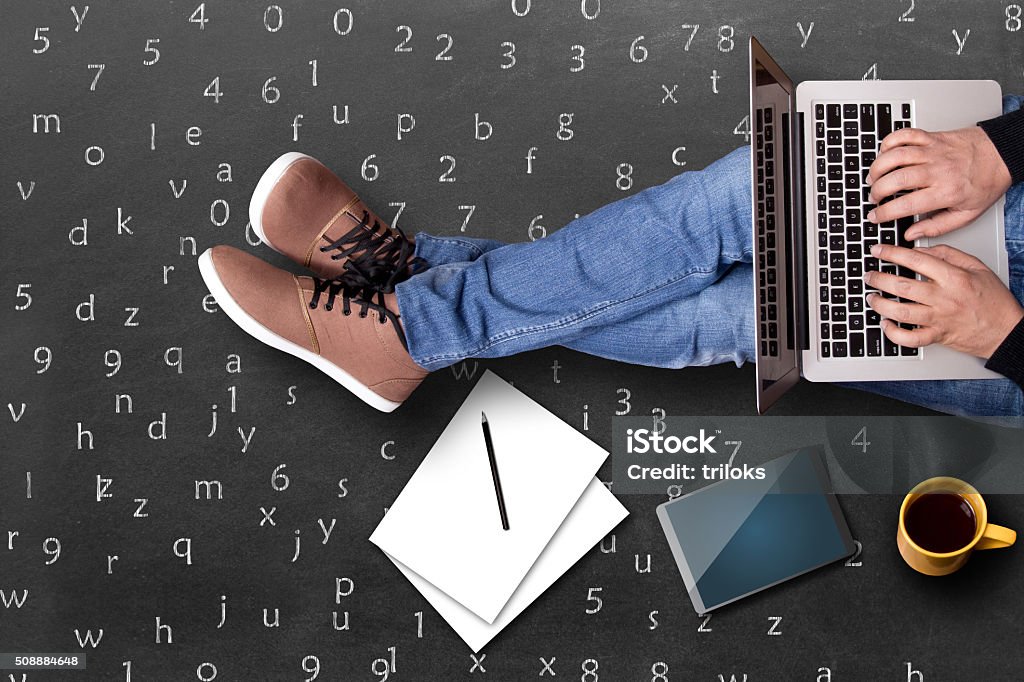 Low section view of a student using laptop High angle view of a student using laptop with black tea, Digital Tablet and notebook. Concept of online education. Connection Stock Photo