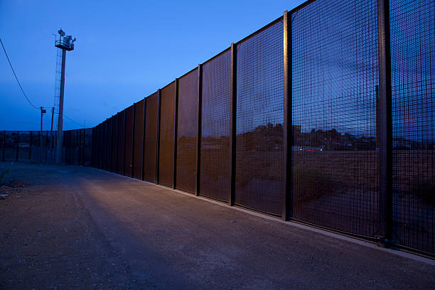 U.S. Border Fence with Mexico at night stock photo
