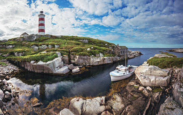 Moored at the Lighthouse A fishing boat is moored in a narrow harbour at Sambro Island Lighthouse.  Built in 1758 it is the oldest operating lighthouse in North America. maritime provinces stock pictures, royalty-free photos & images