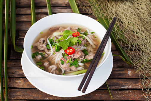 Traditional Vietnamese beef soup pho on a wooden background