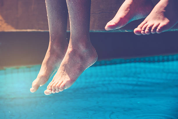 istock naked feet over blue swimming pool 508899862