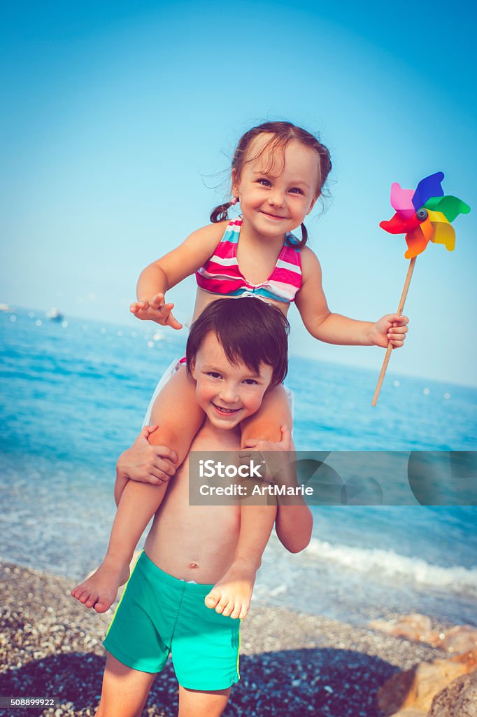 Children on the beach Happy little boy and girl having fun by the sea 6-7 Years Stock Photo