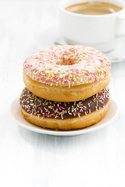 istock glazed donuts and cup of coffee on white table 508900552