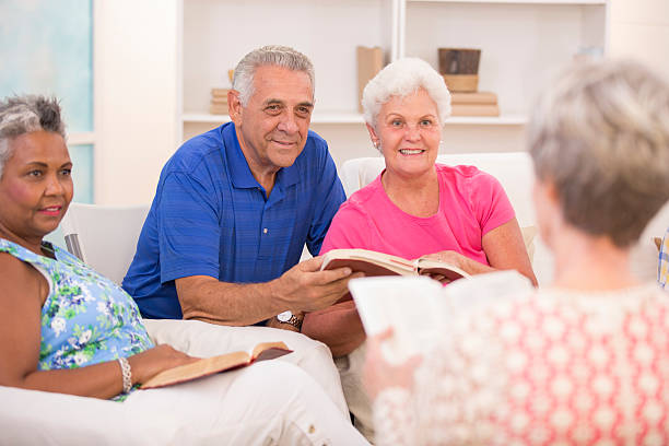 Senior adult friends, couple during bible study group. Group of senior adults during a bible study.  Multi-ethnic group reading bible together.  bible study group of people small group of people stock pictures, royalty-free photos & images