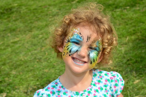 Pretty young girl with a butterfly face painting.