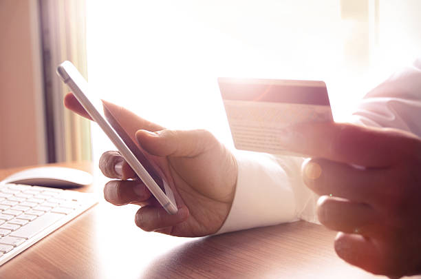 istock Man's hands holding credit cards and using mobile phone 508914842