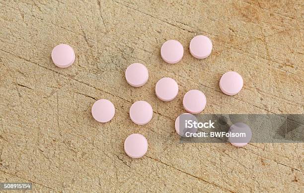 Famotidine Tablets On A Wood Cutting Board Stock Photo - Download Image Now - Brown, Cutting Board, Dose