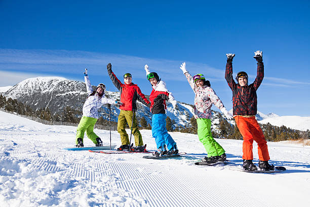 istock Snowboards, skies standing lifting hands up 508915180