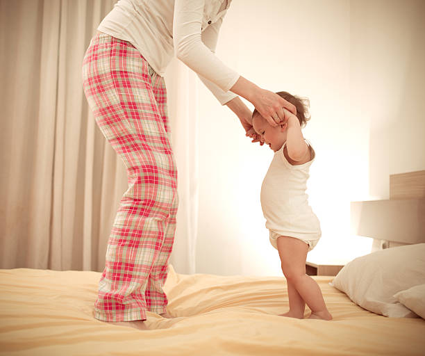 istock woman playing with her son on the bed 508915900