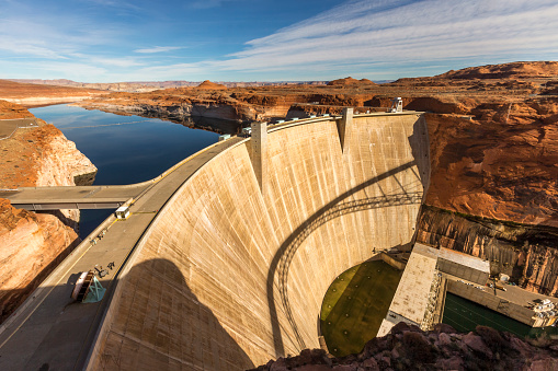 Glen Canyon Dam is a concrete arch dam on the Colorado River in northern Arizona in the United States, near the town of Page. The dam was built to provide hydroelectricity and flow regulation from the upper Colorado River Basin to the lower. Its reservoir is called Lake Powell, and is the second-largest artificial lake in the country.