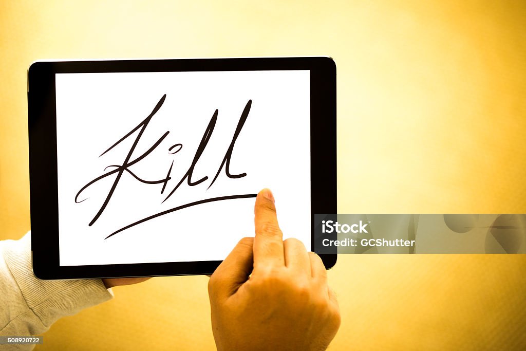 Word "Kill" on a Digital Tablet Man holding a digital tablet with "Kill" written over white background. A high contrast composition. Abstract Stock Photo