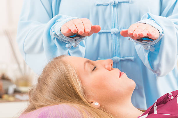 professionnels de reiki de guérison - reiki alternative therapy massaging women photos et images de collection