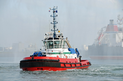 A tug on its way to an oiltanker in a foggy port of Rotterdam