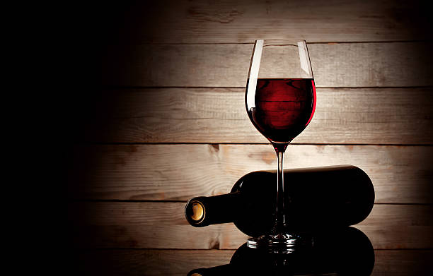 istock Glass of red wine and bottle lying on its side 508934469
