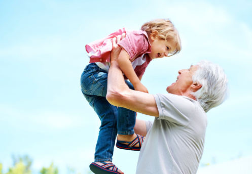 Shot of a happy grandfather playing with his grandson and lifting him in the air