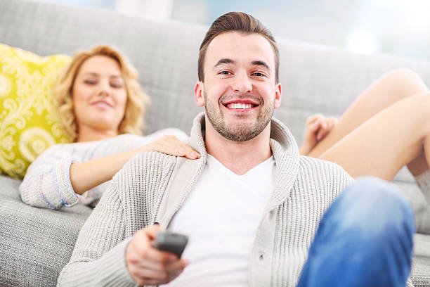 istock Happy couple watching tv at home 508940682