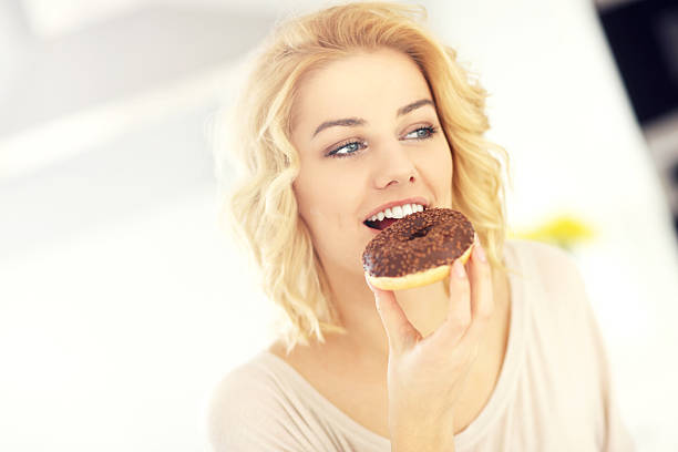 istock Young woman with donut in the kitchen 508941768