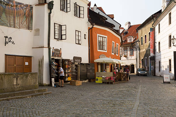 Cesky Krumlov, Czech Republic - July 19, 2013: Cesky Krumlov early morning. Tourists are breakfast, shopkeepers open their gift shops for tourists. Cesky Krumlov is small town on south of Czech Republic. Well known by it's arhitecture. Center of city was added to the UNESCO list of World Heritage Sites. Construction of the town and castle began in the late 13th century.