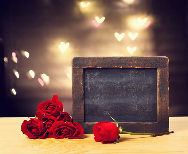 istock Blank chalkboard with red roses 508942322