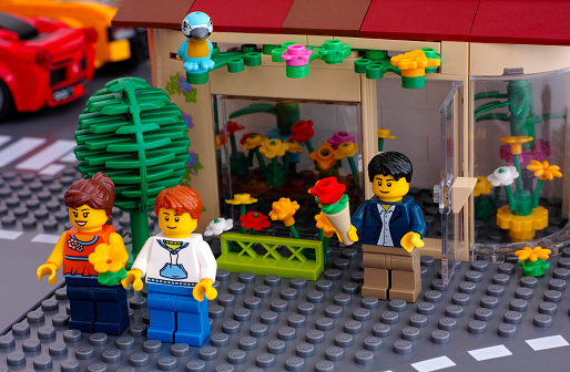 Tambov, Russian Federation - March 11, 2015: Lego street with flowers shop, man and couple minifigures with bouquets. Custom set. Studio shot.