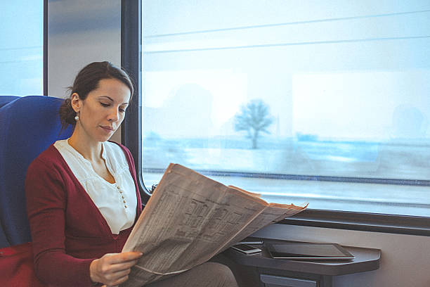 istock Young business woman reading newspaper while commuting to work 508945982