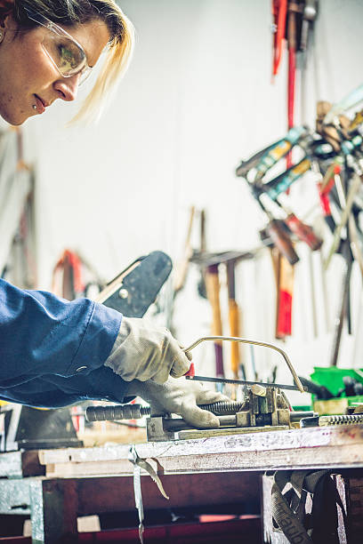istock Woman Using Iron Saw in Mechanical Workshop 508946062