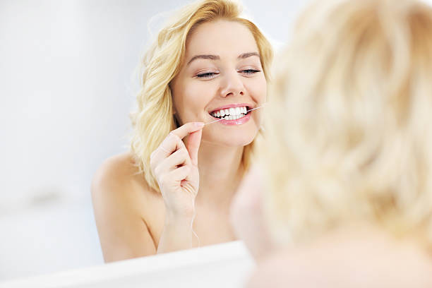 donna con filo interdentale - healthy lifestyle human teeth adult brushing foto e immagini stock